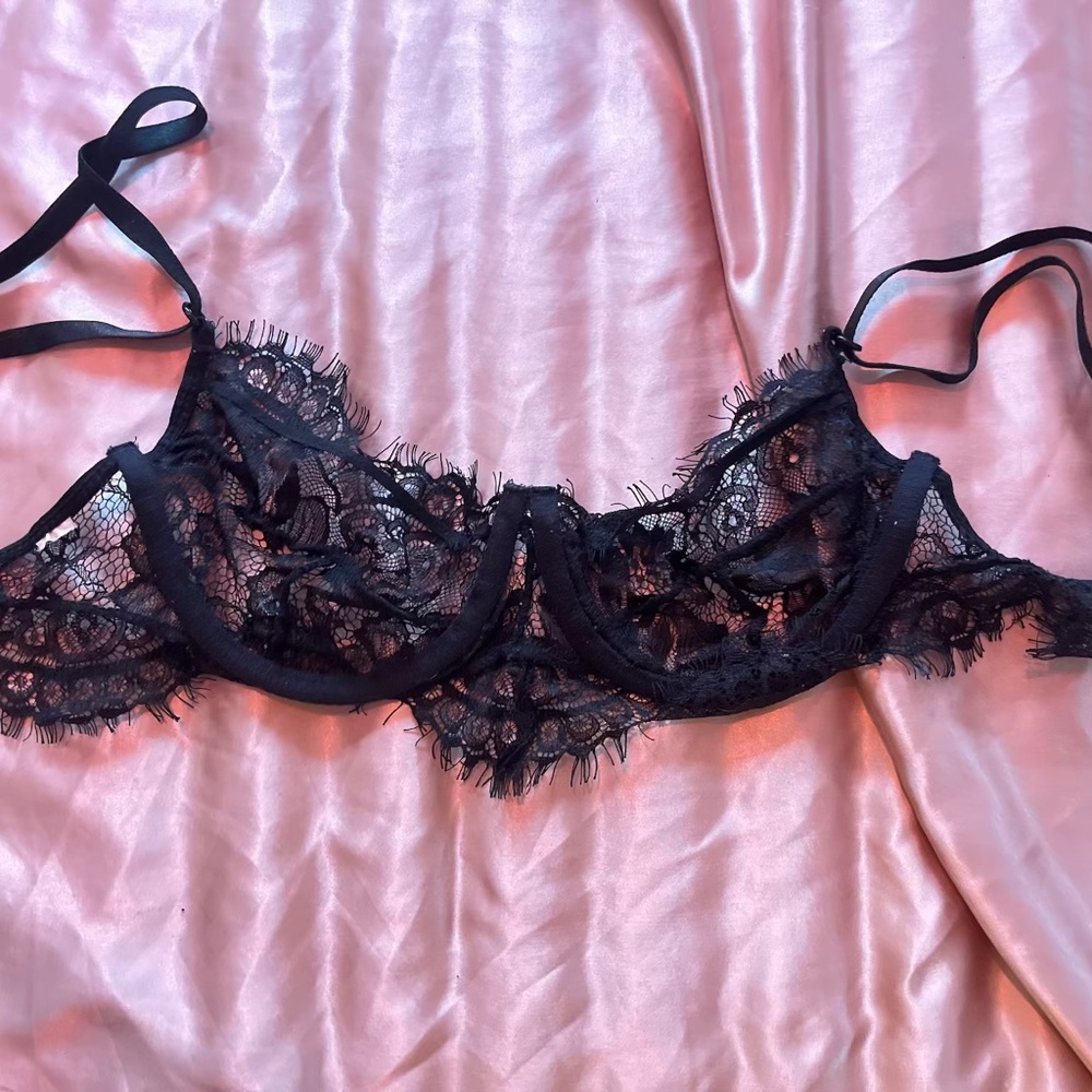 Small black lacy cupless bra.